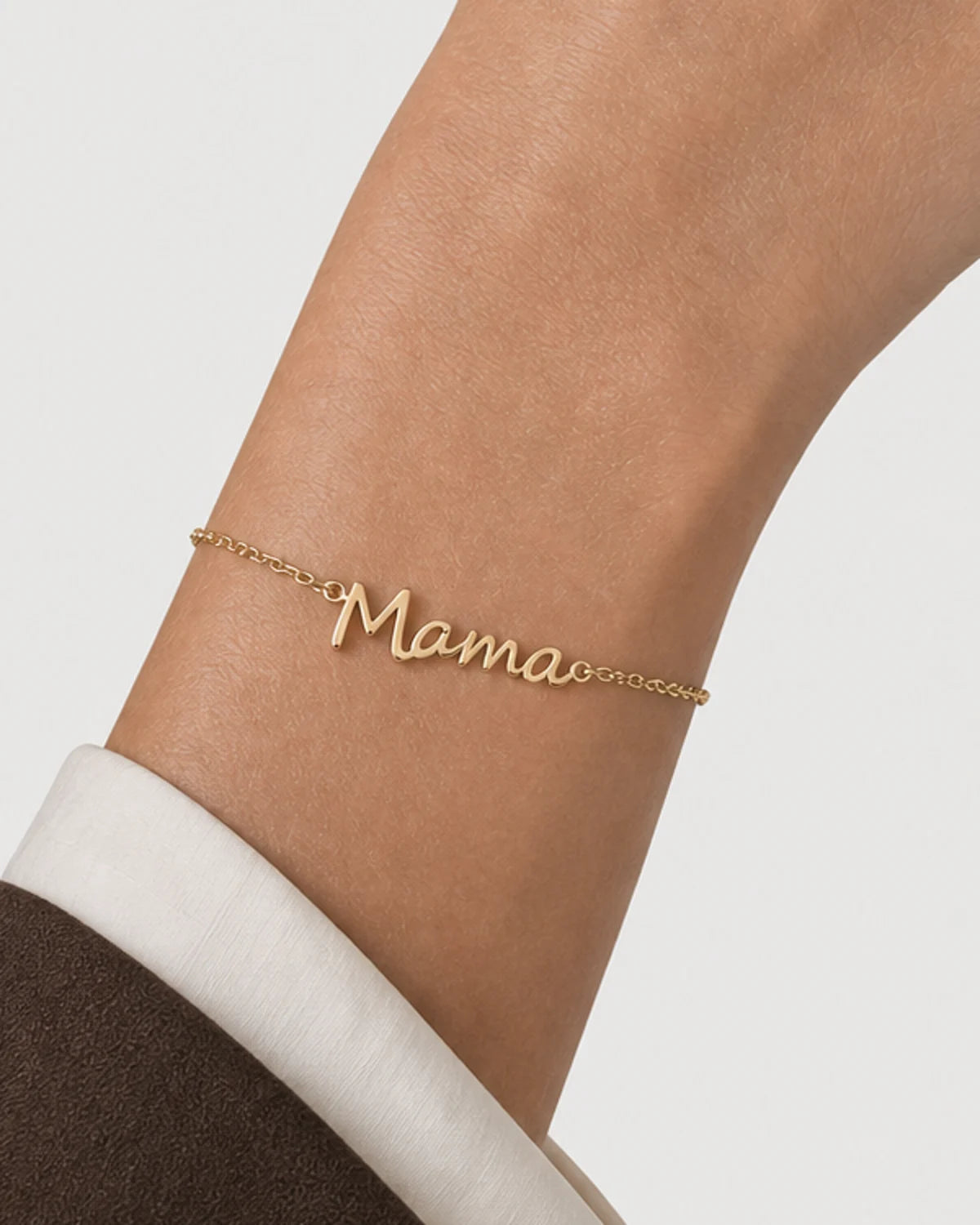 Extreme on-body macro of the Sera polished Mama script and fine chain