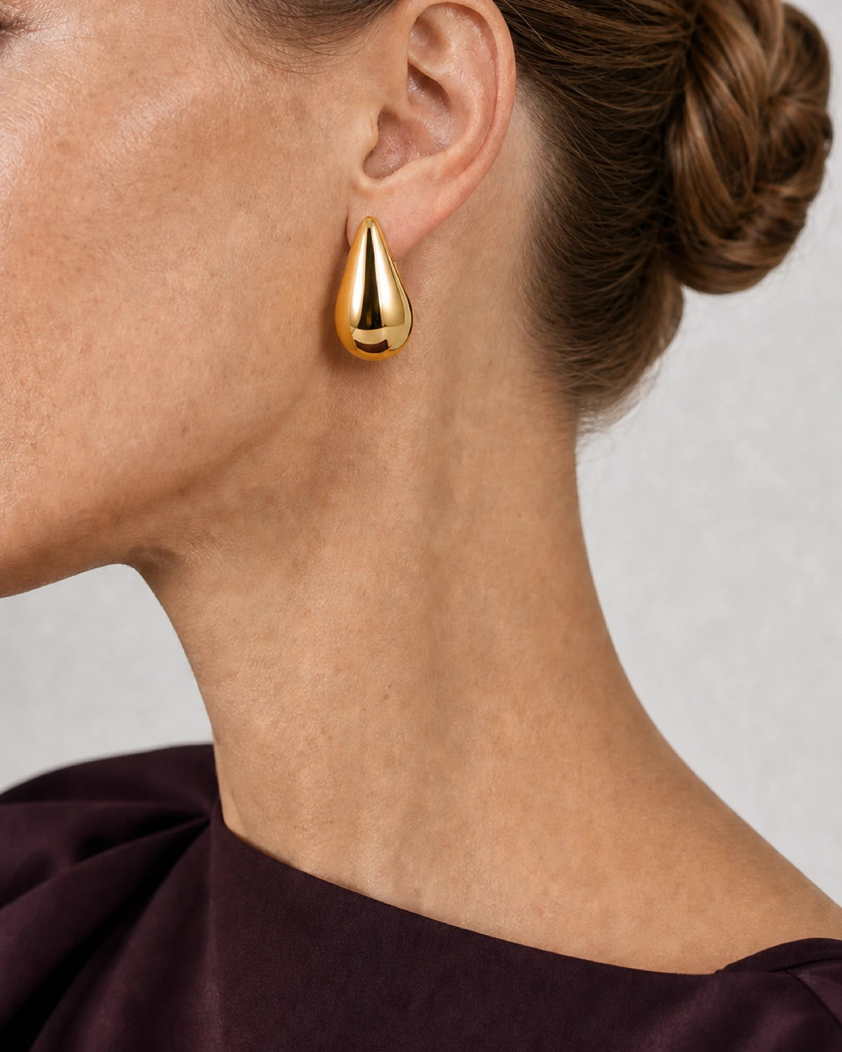 Complete worn macro of the gold Solène sculpted teardrop earring