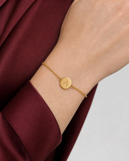 Complete worn macro of the Amara gold initial bracelet and fine cable chain