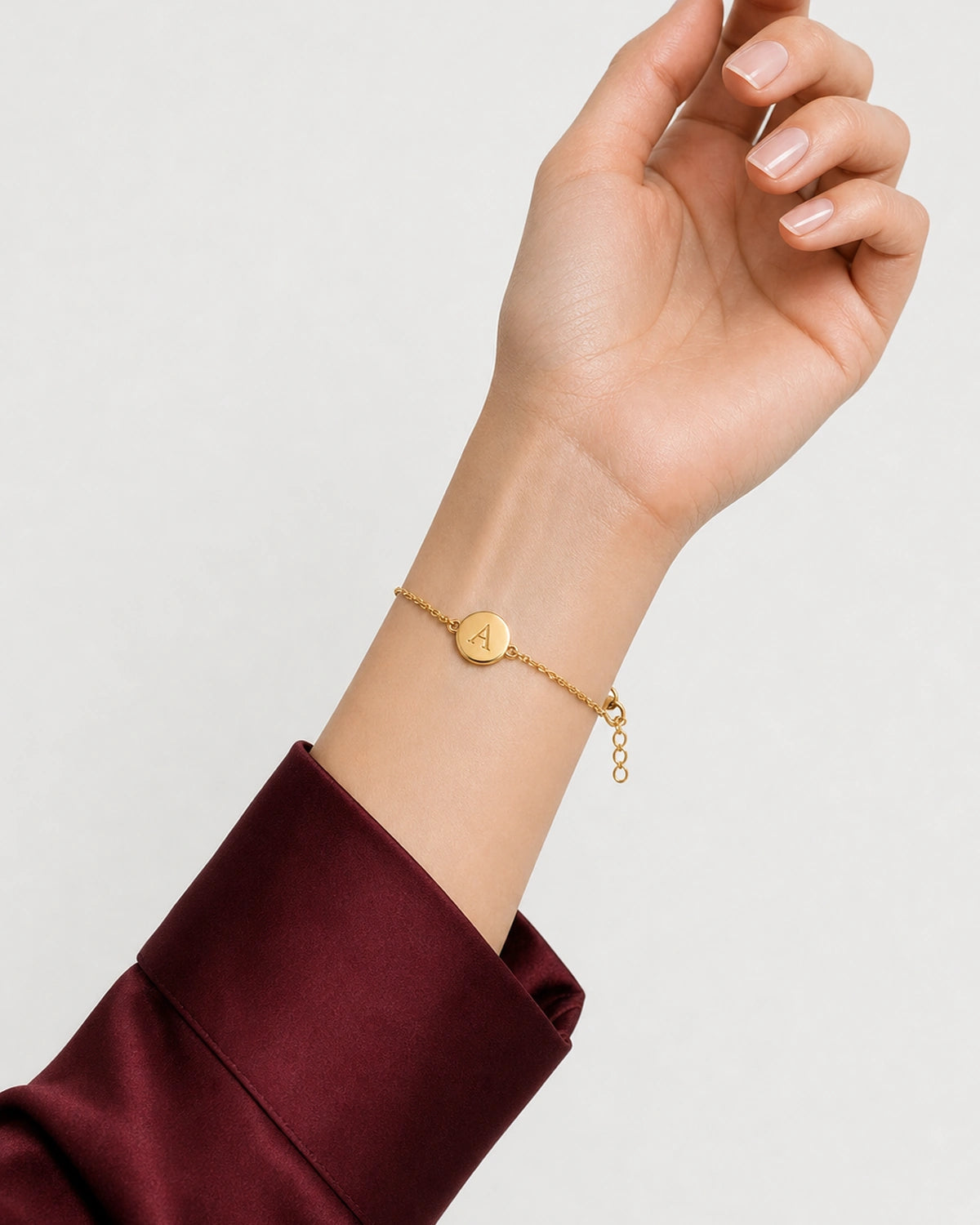 Amara gold initial bracelet shown in a palm-up wearing pose