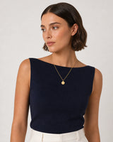 Model in navy knit and cream summer linen wearing the Amara A medallion necklace
