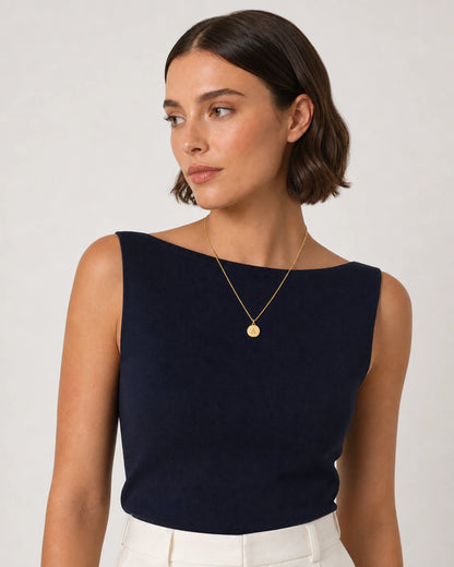 Model in navy knit and cream summer linen wearing the Amara A medallion necklace