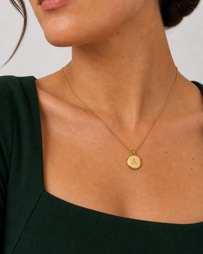 Alternate mouth-and-chin-down portrait wearing the gold Amara serif-A medallion