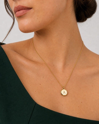 Alternate lower-face wearing view of the gold Amara initial medallion