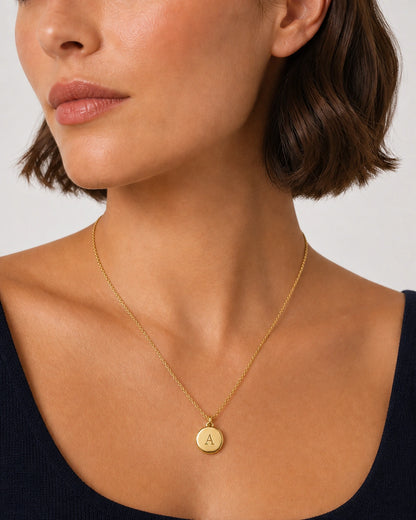 Close wearing view of the Amara round gold medallion with serif A