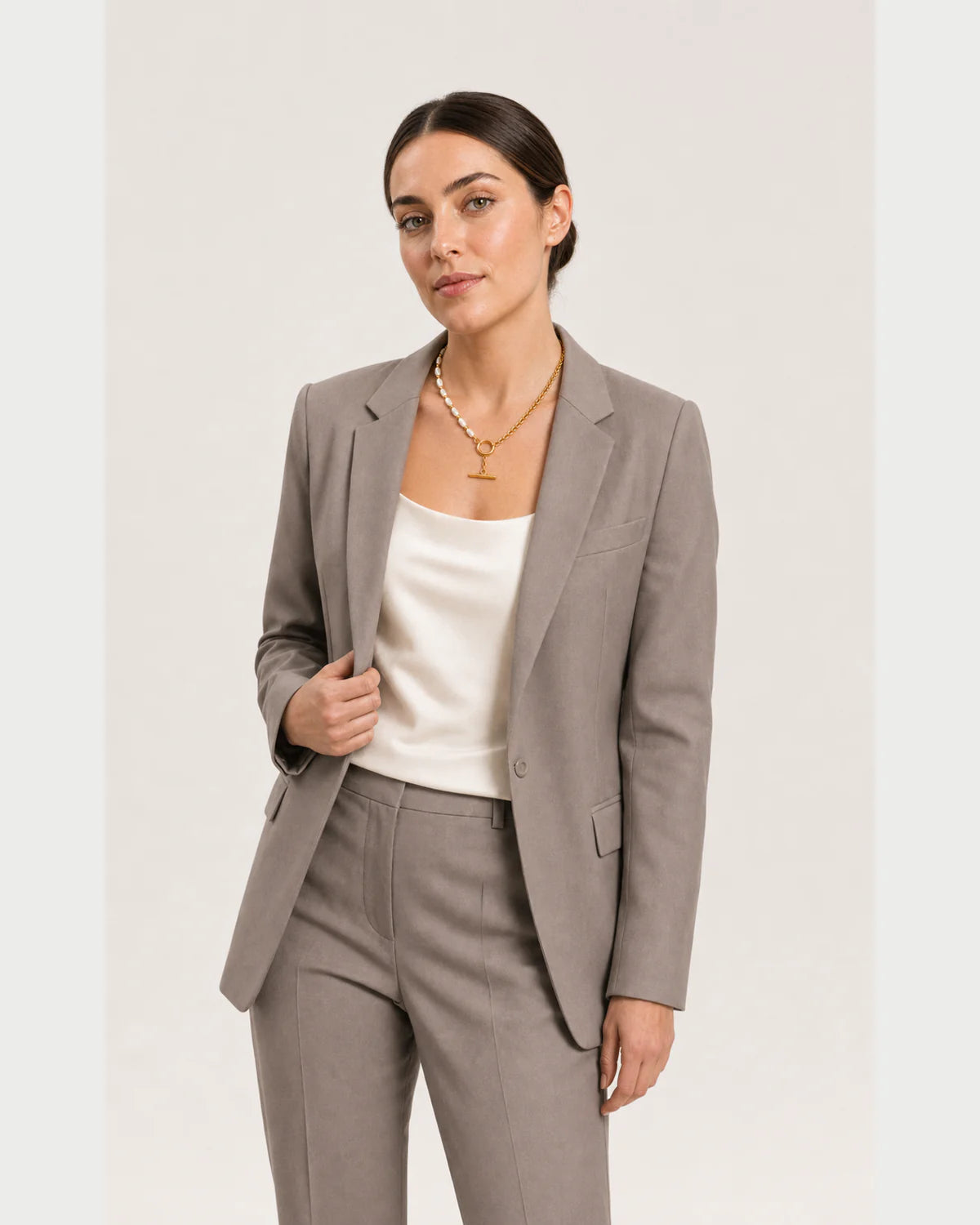 Wide grey-studio editorial portrait featuring the Amélie necklace