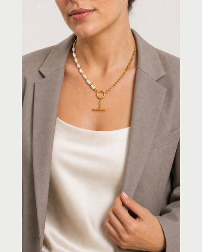 Model holding her blazer lapel while wearing the Amélie necklace