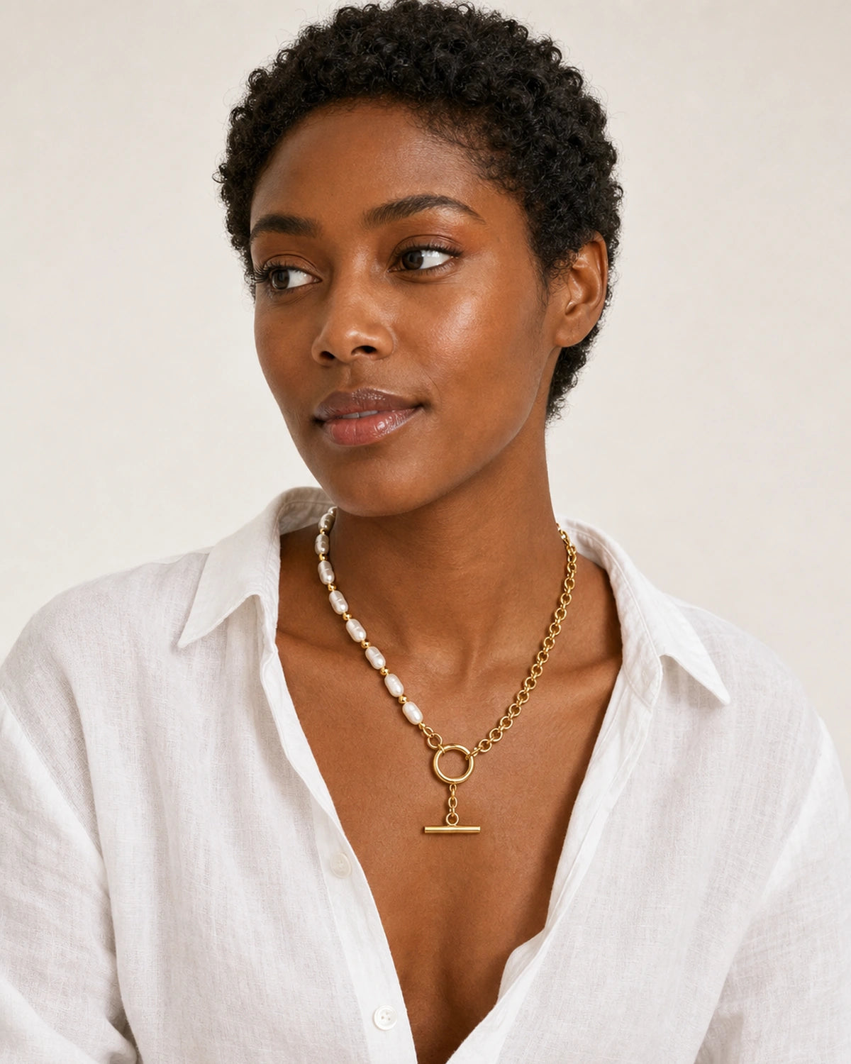 Model in a relaxed white Côte d’Azur linen shirt wearing the Amélie pearl and chain toggle necklace