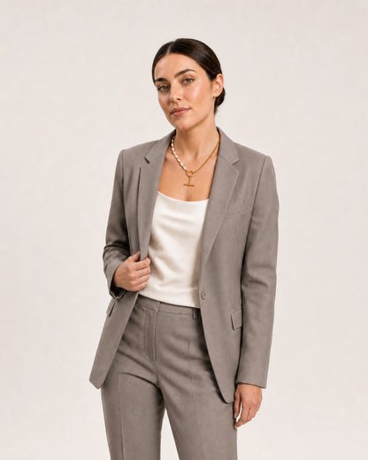 Wide grey-studio editorial portrait featuring the Amélie necklace