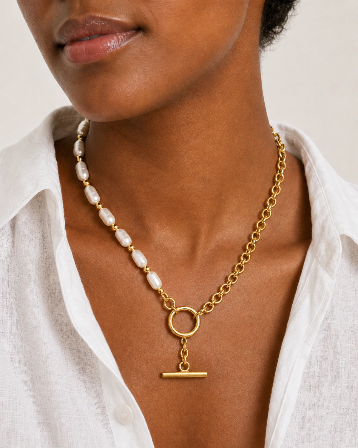 Close neckline view of Amélie pearls, gold chain, toggle ring and T-bar