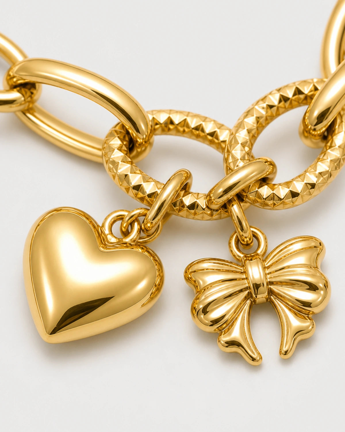 Macro of an Amorette puffed heart, sculpted bow and alternating smooth and faceted links