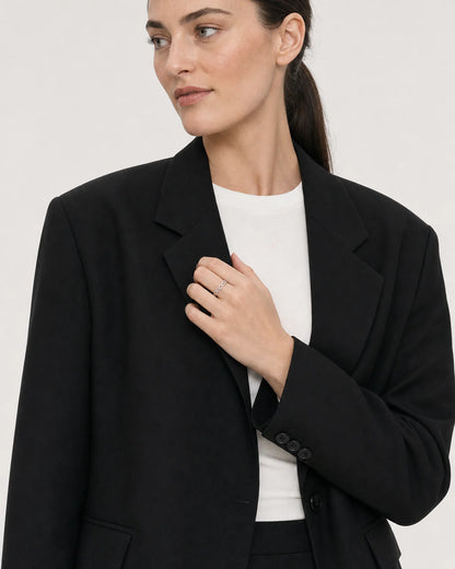 Wide grey-studio editorial portrait featuring the Amoura silver ring
