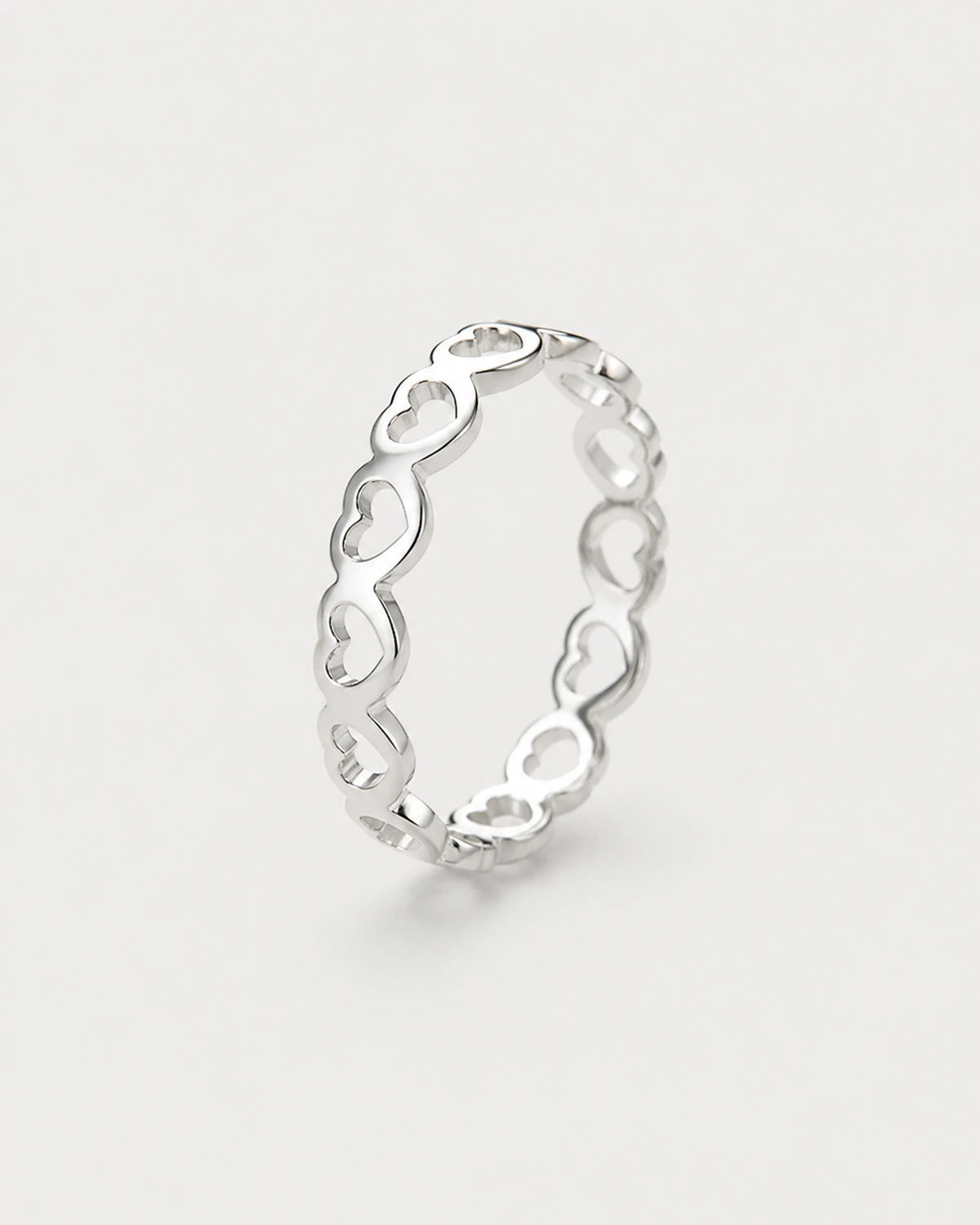 Amoura silver open-heart band ring on pale dove-grey