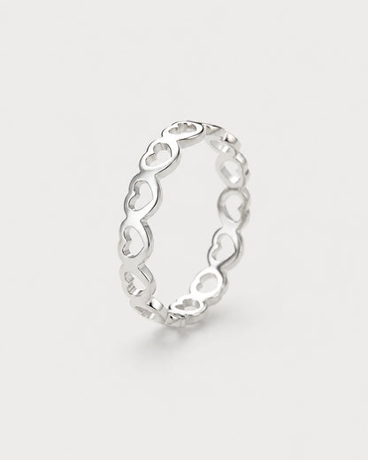 Amoura silver open-heart band ring on pale dove-grey