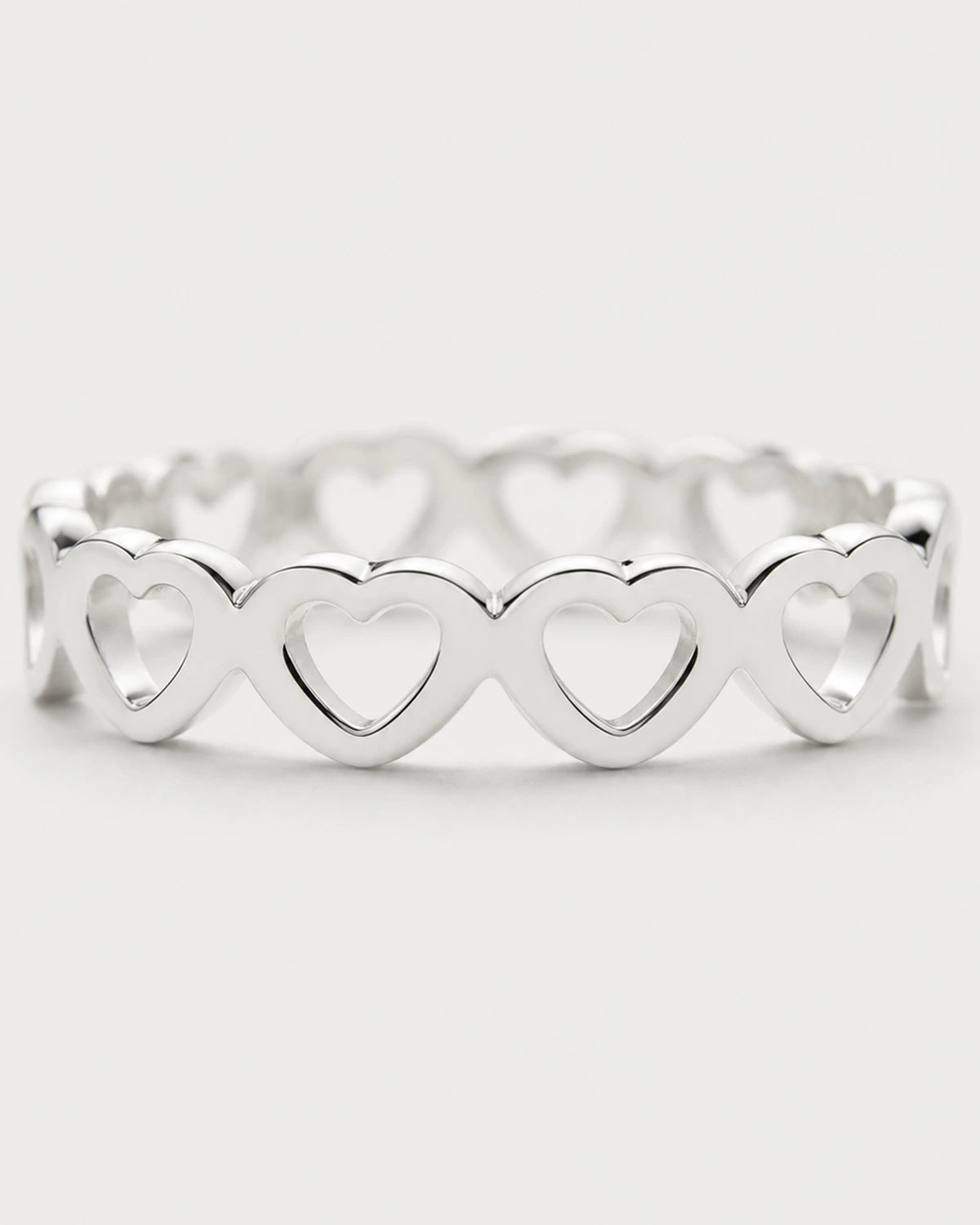 Macro view of the repeating upright hearts on the Amoura silver ring
