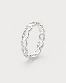 Amoura silver open-heart band ring on seamless pale neutral grey