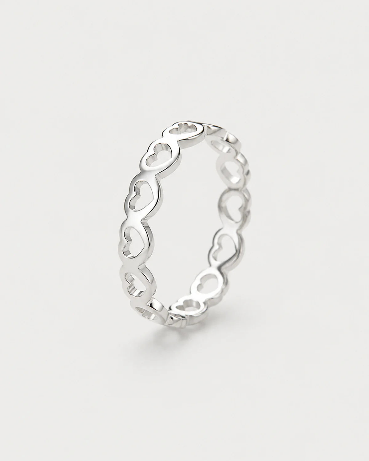 Amoura silver open-heart band ring on seamless pale neutral grey