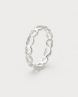 Amoura silver open-heart band ring on seamless pale neutral grey