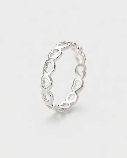 Amoura silver open-heart band ring on seamless pale neutral grey