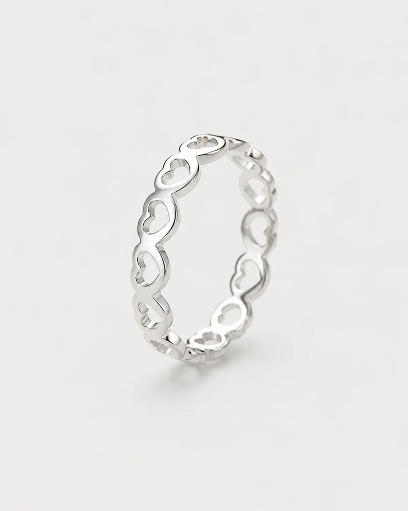 Amoura silver open-heart band ring on seamless pale neutral grey