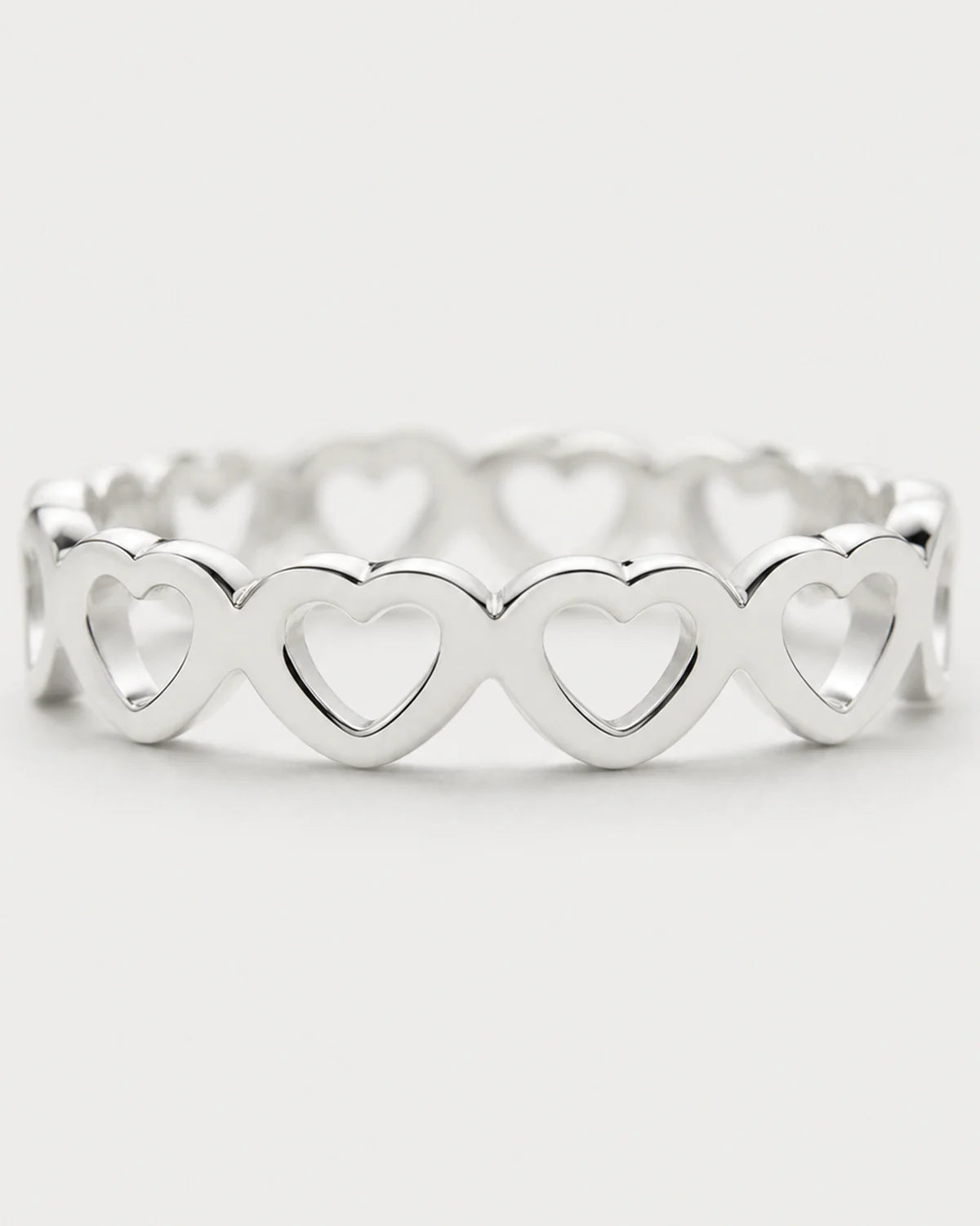Macro of the repeating upright hearts and polished silver Amoura band