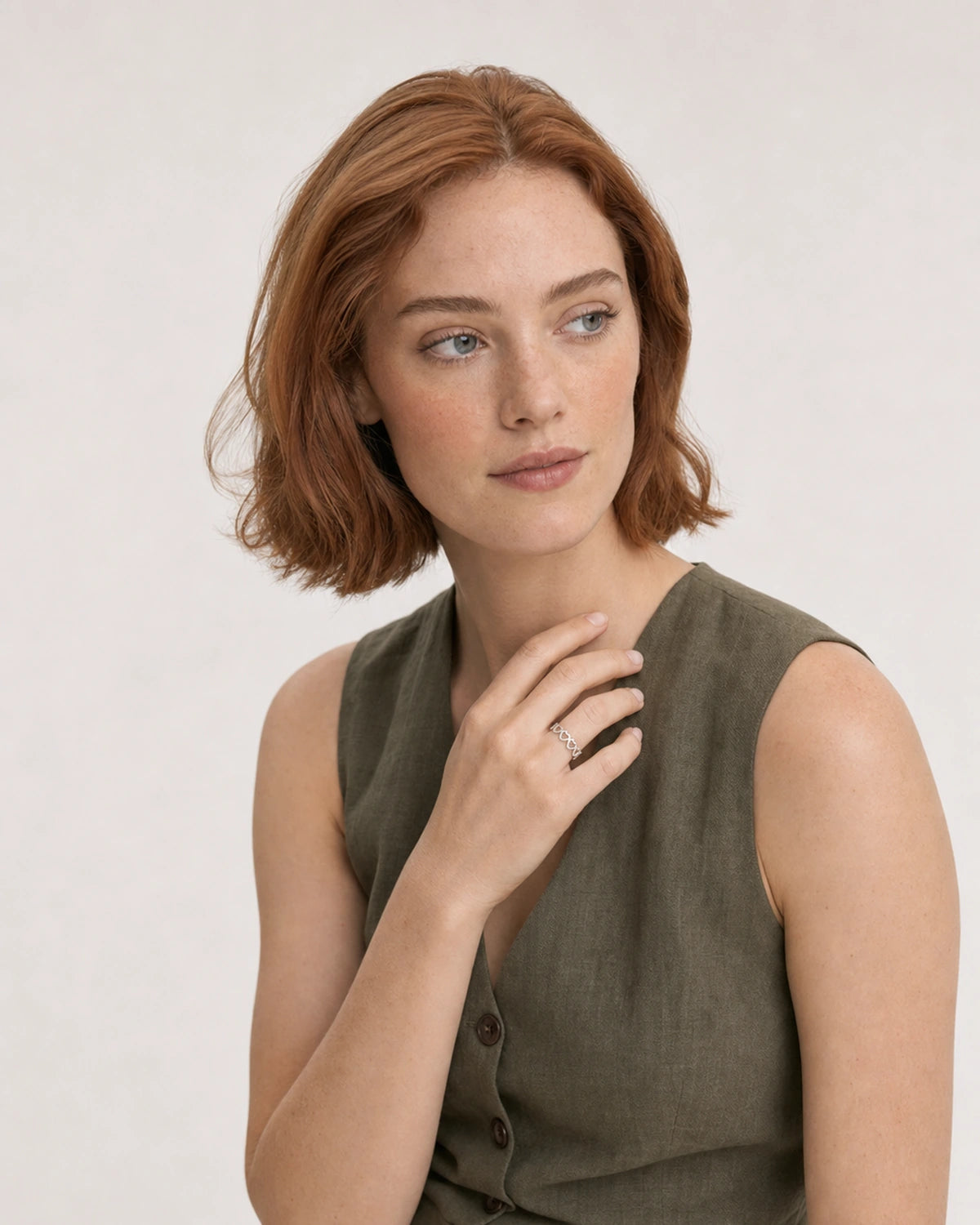 Model in an olive Tuscany linen waistcoat top wearing the Amoura silver open-heart ring