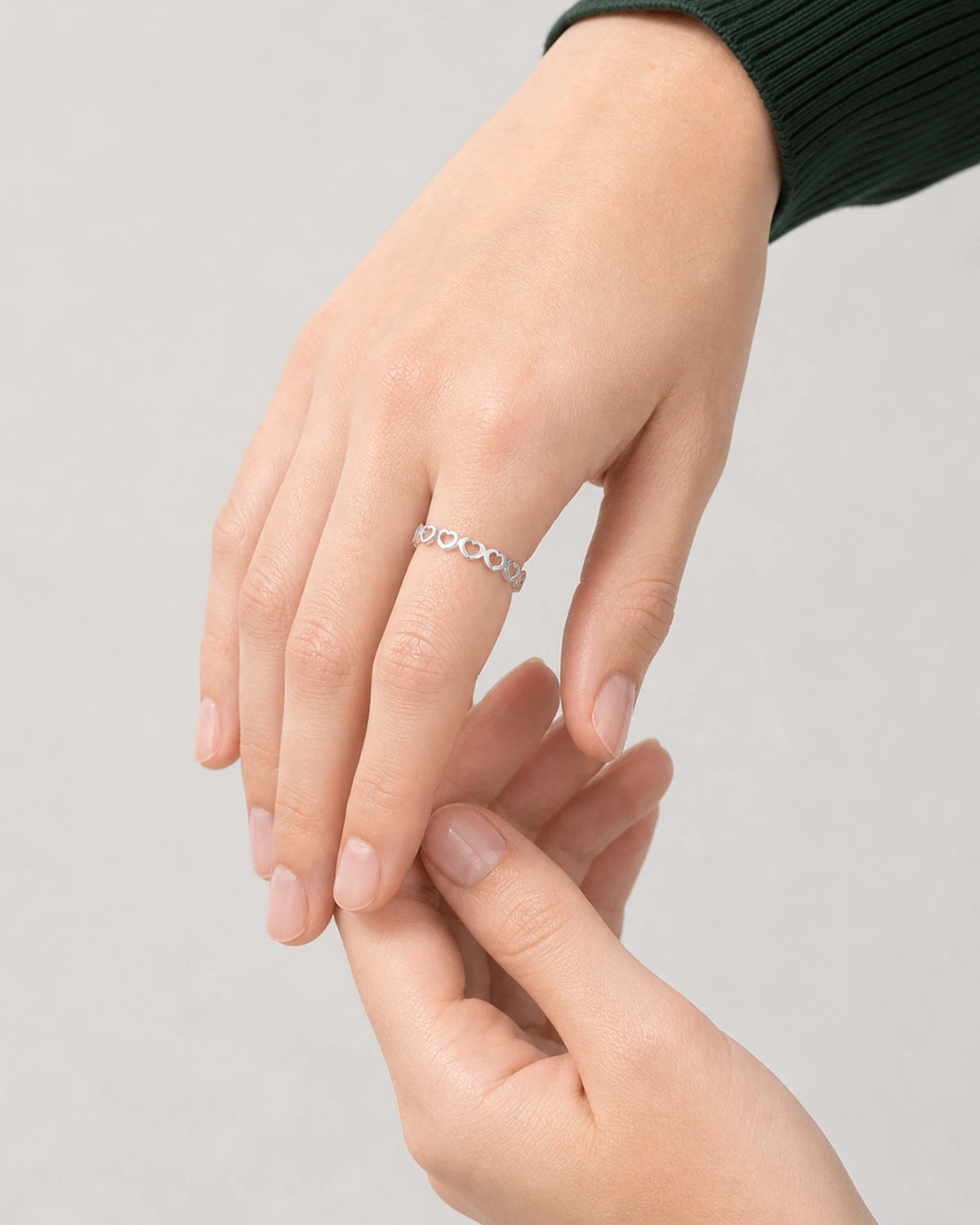 Three-quarter hand pose of Camille wearing the silver Amoura heart band
