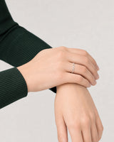 Crossed-wrist editorial hand pose featuring the silver Amoura open-heart ring