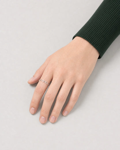 Top-down hand view of Camille wearing the slim silver Amoura heart ring