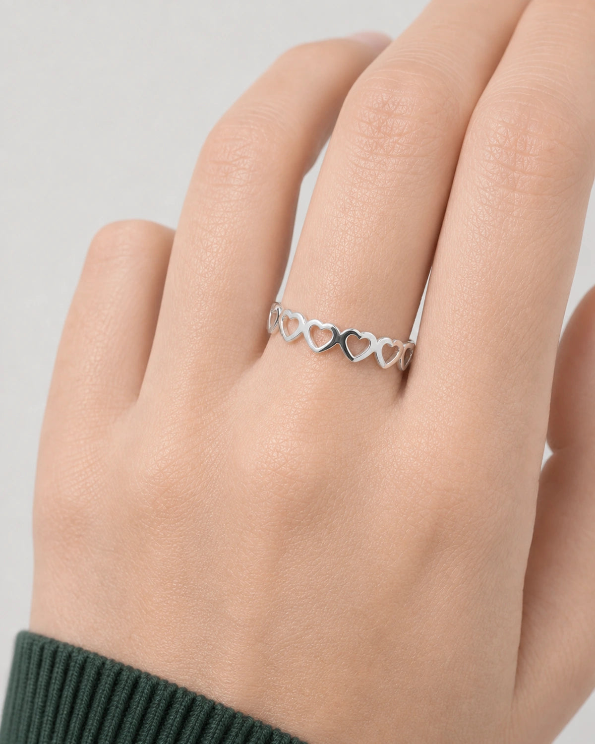 Complete worn macro of the silver Amoura open-heart band at natural scale