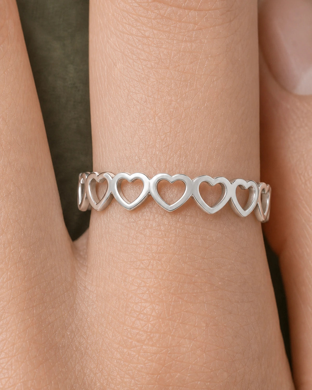 Extreme on-hand macro of the Amoura repeating upright silver hearts