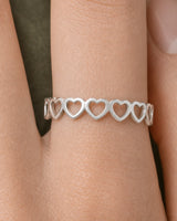 Extreme on-hand macro of the Amoura repeating upright silver hearts