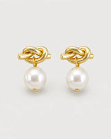Apolline gold knot pearl drop earrings on pale dove-grey