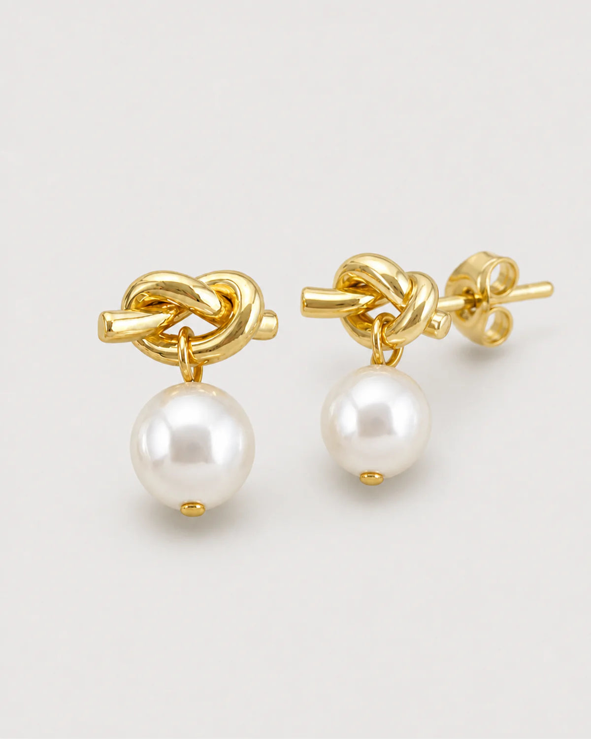 Macro view of the Apolline gold knot, pearl drops and stud backs