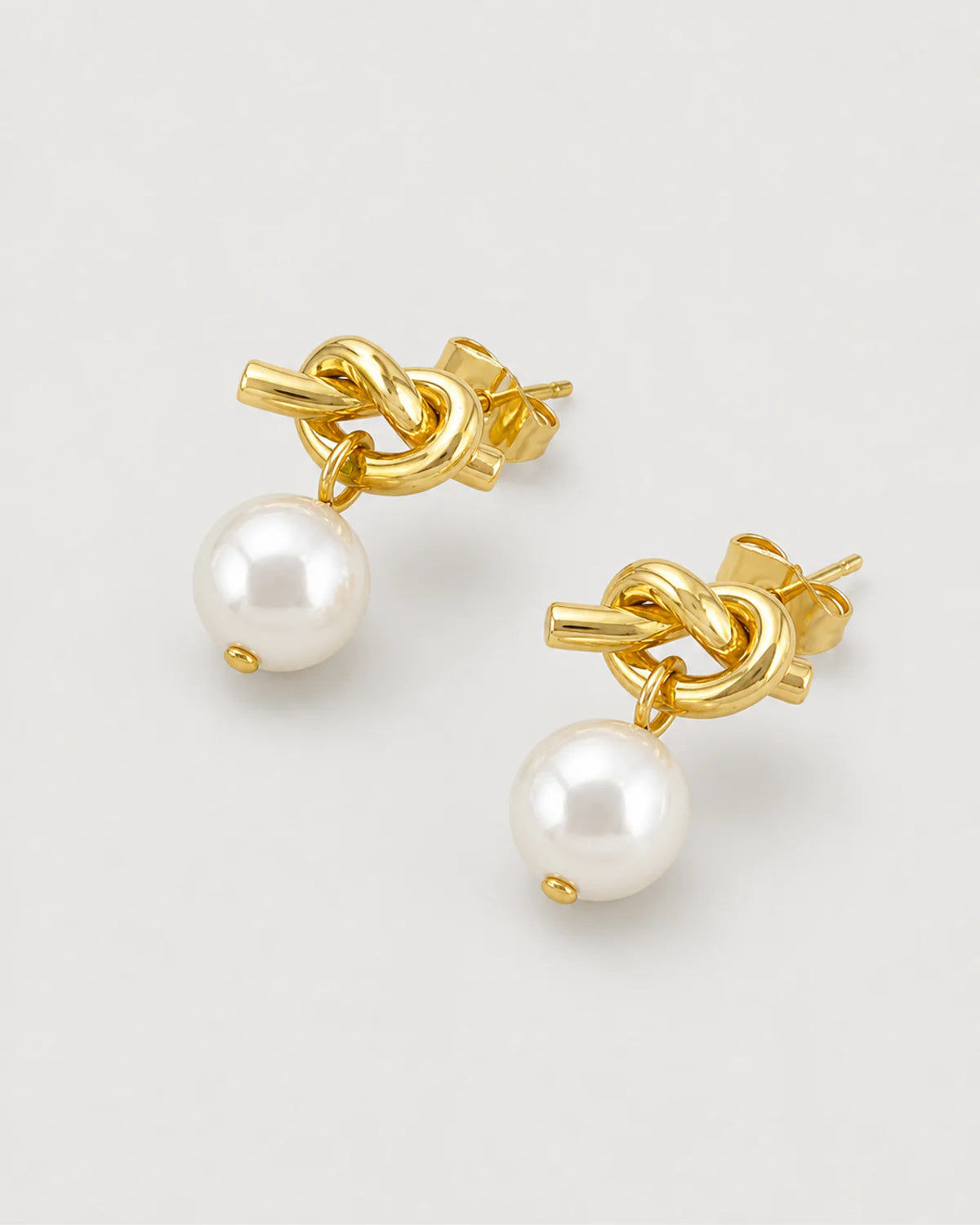 Apolline gold knot pearl earrings in an alternate studio arrangement