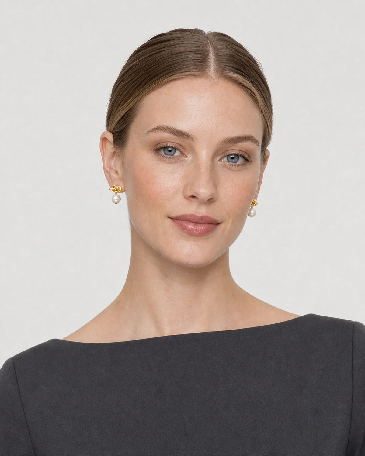 American model wearing the Apolline gold knot pearl earrings