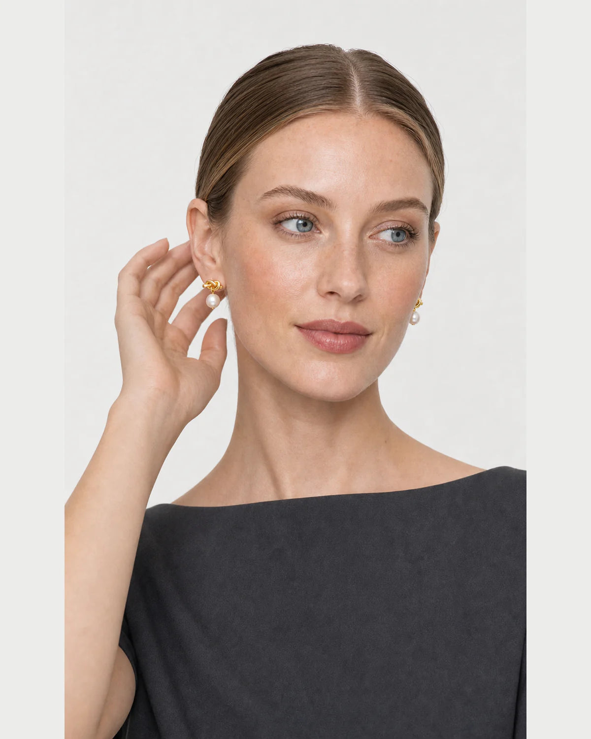 Human-scale portrait with a hand gesture beside the Apolline earring