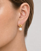 Extreme on-ear macro of the Apolline gold knot and pearl drop