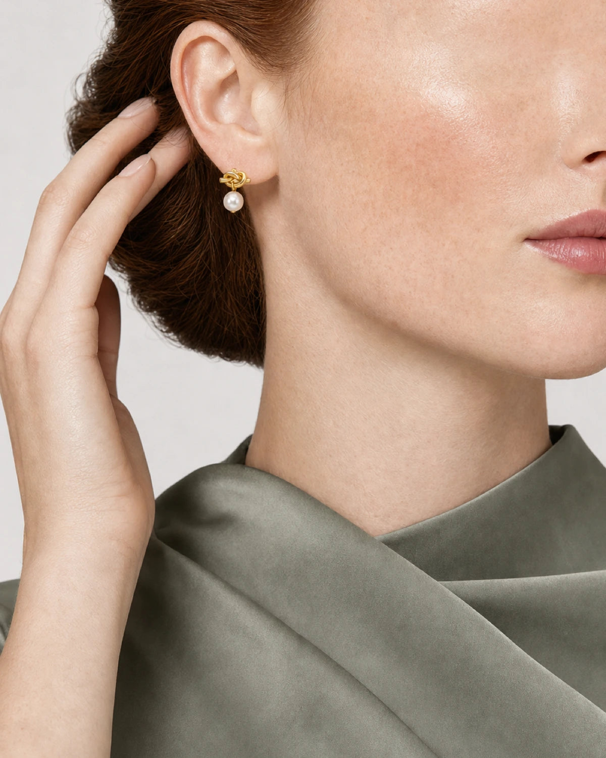 Eye-free hair gesture beside Laurel's gold Apolline pearl earring