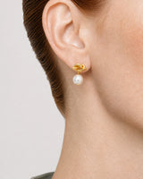 Complete worn macro of the gold Apolline love-knot and pearl drop on Laurel