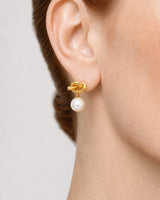 Extreme worn macro of the gold Apolline tubular knot, jump ring and pearl