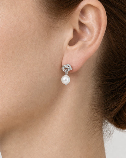 Complete rear-side worn macro of the silver Apolline knot pearl earring