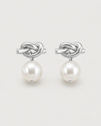 Apolline silver knot pearl drop earrings on pale dove-grey