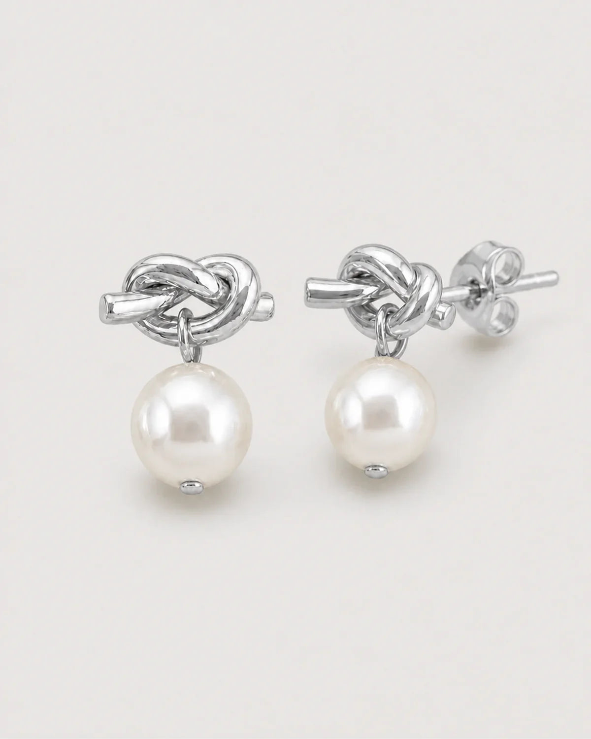 Macro view of the Apolline silver knot, pearl drops and stud backs