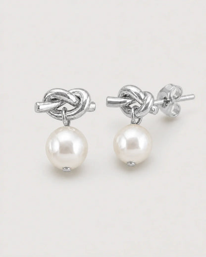 Macro view of the Apolline silver knot, pearl drops and stud backs