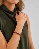 Chin-down collarbone pose showing the slim profile of the espresso Arden bangle