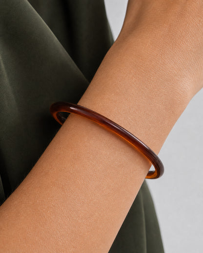 True worn macro of the complete espresso Arden Slim Resin Bangle around the wrist