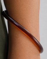 Extreme worn macro showing the translucent espresso construction of the Arden bangle