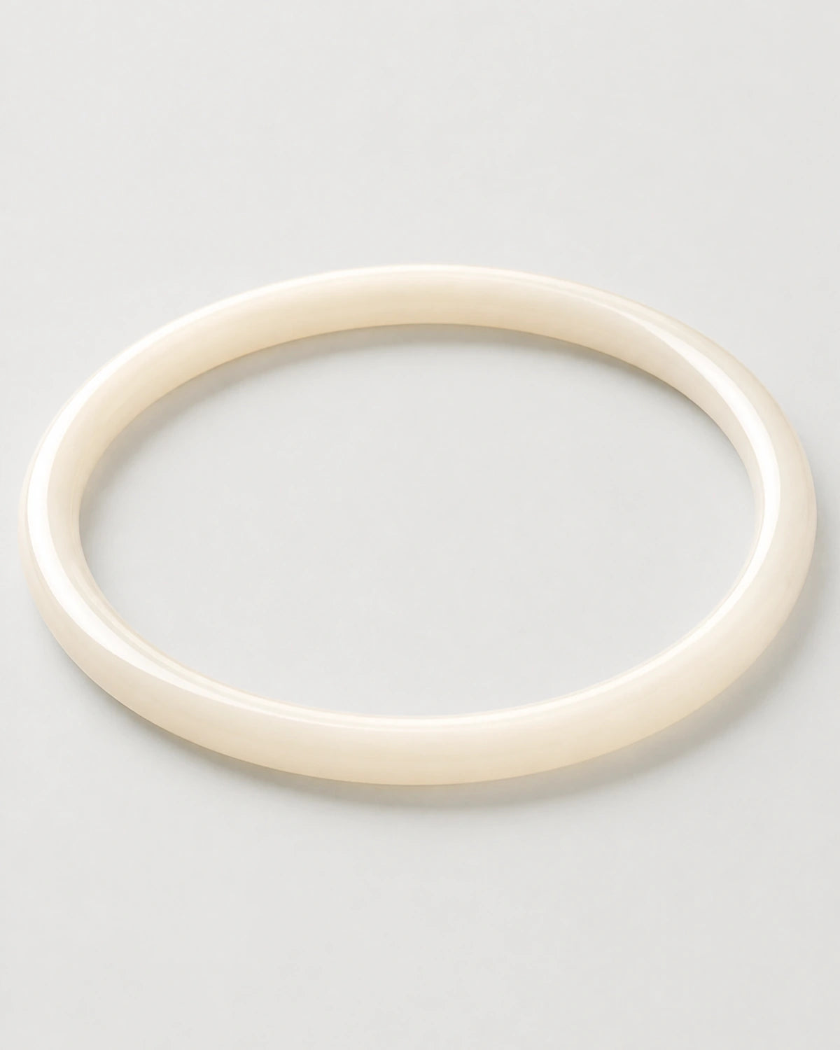 Alternate flat-lay view of the seamless Arden slim ivory bangle