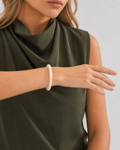 Horizontal forearm view of Lucy wearing the slim ivory Arden resin bangle